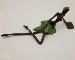 Liggende dame met boek in brons